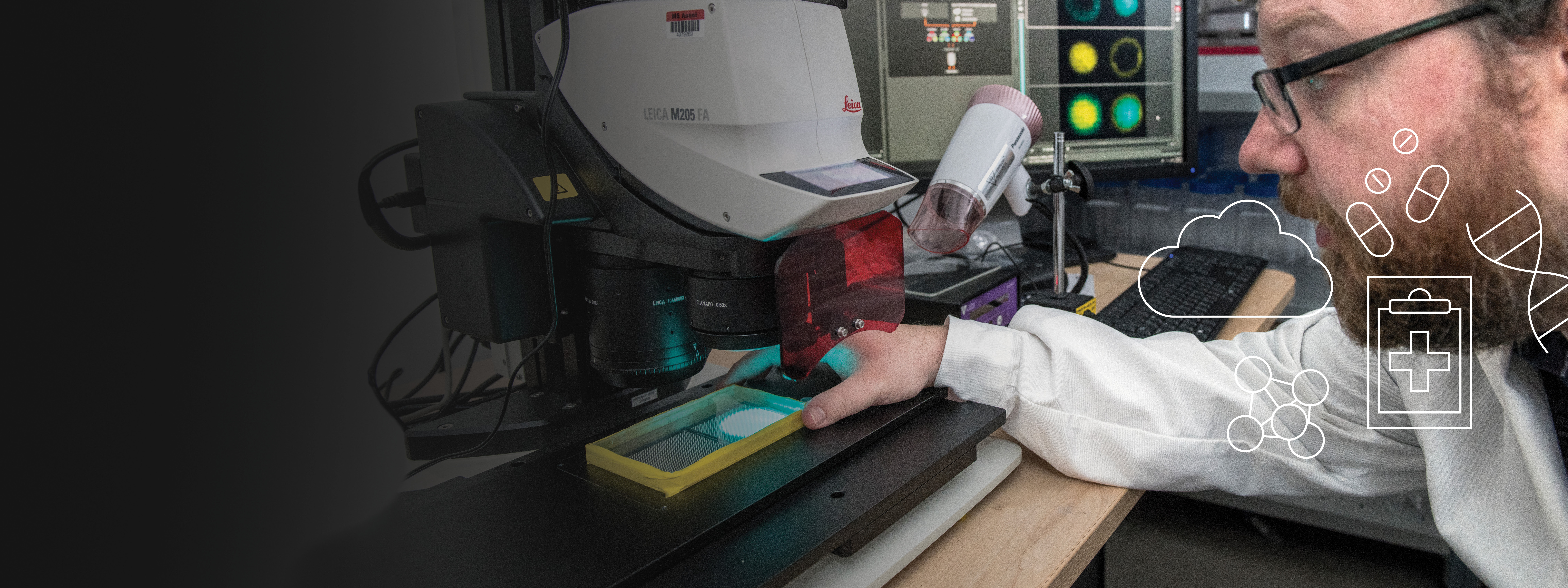 Station B researcher studying a microscope