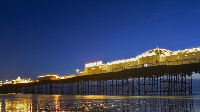 Photo of the Brighton (UK) pier at night reflected in the water