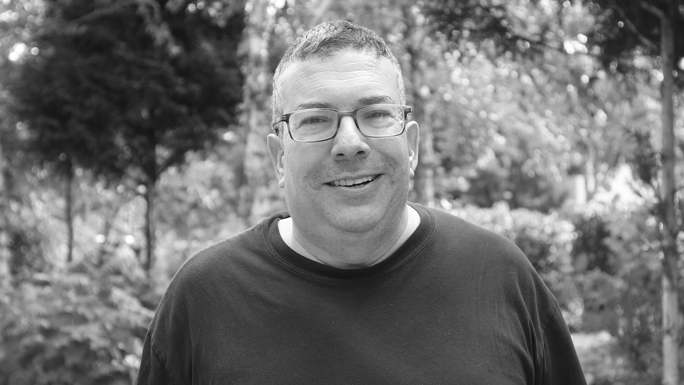 a man wearing glasses and smiling at the camera