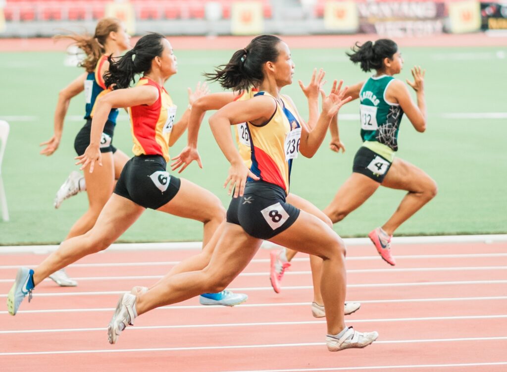 Four runners compete at a full sprint.