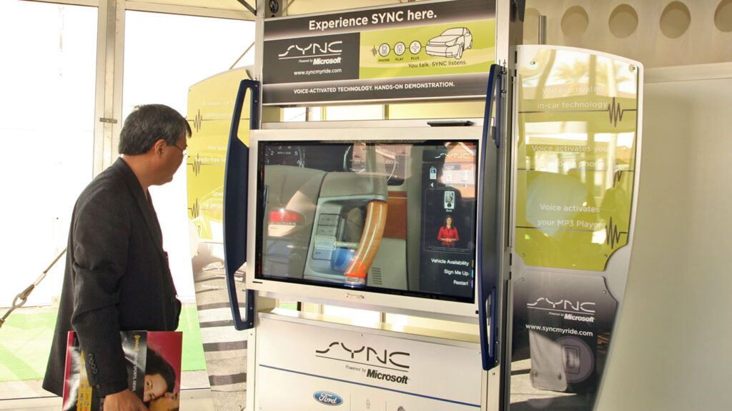 audio and acoustics: man standing in front of Experience Ford SYNC kiosk