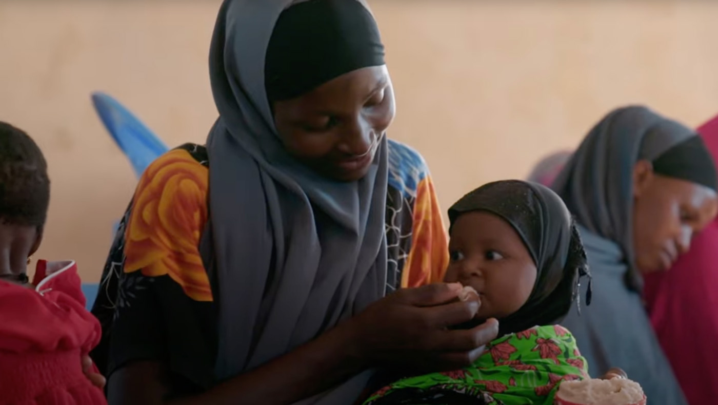 mother feeding child by hand in Africa