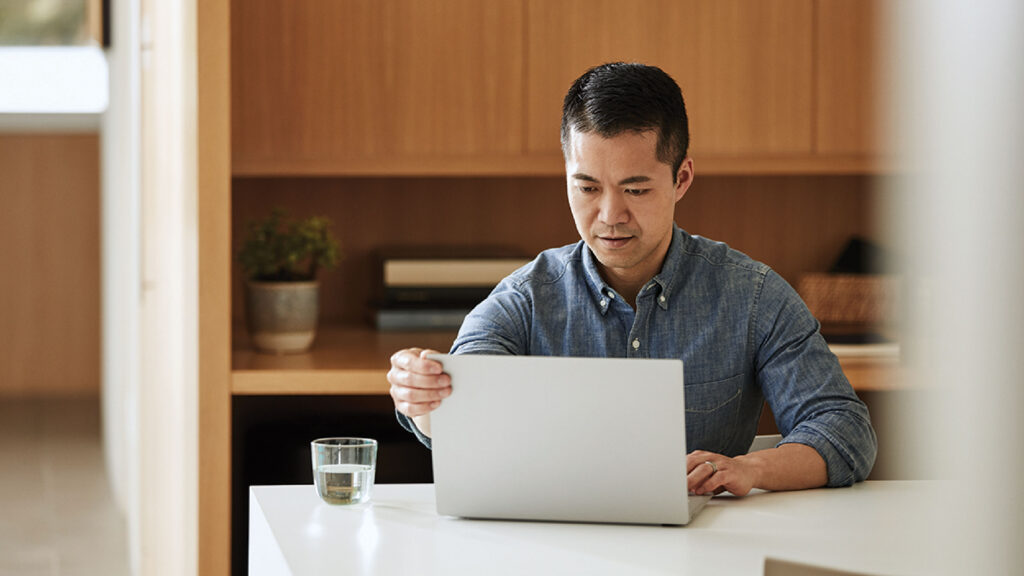 a man sitting at a table using a laptop