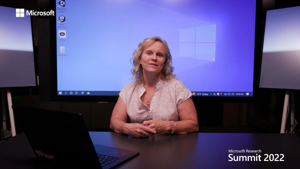 a person sitting at a table in front of a computer screen