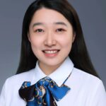 a person wearing a blue shirt and smiling at the camera