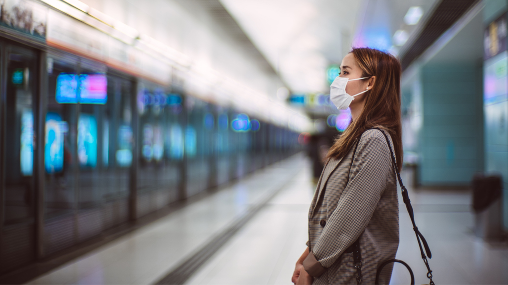 woman wearing a face mask waiting in the subway