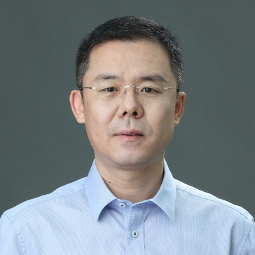 a man wearing glasses and smiling at the camera