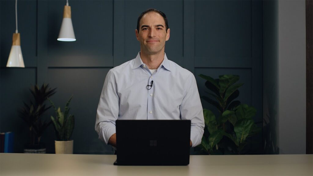 a man standing in front of a laptop computer