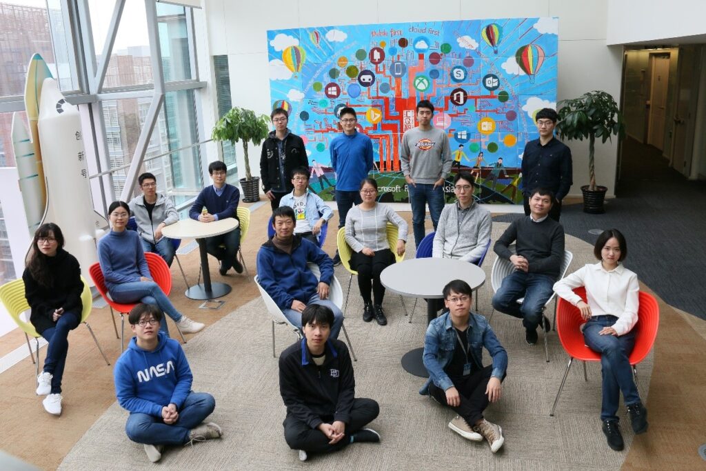 a group of people sitting and standing in front of a crowd