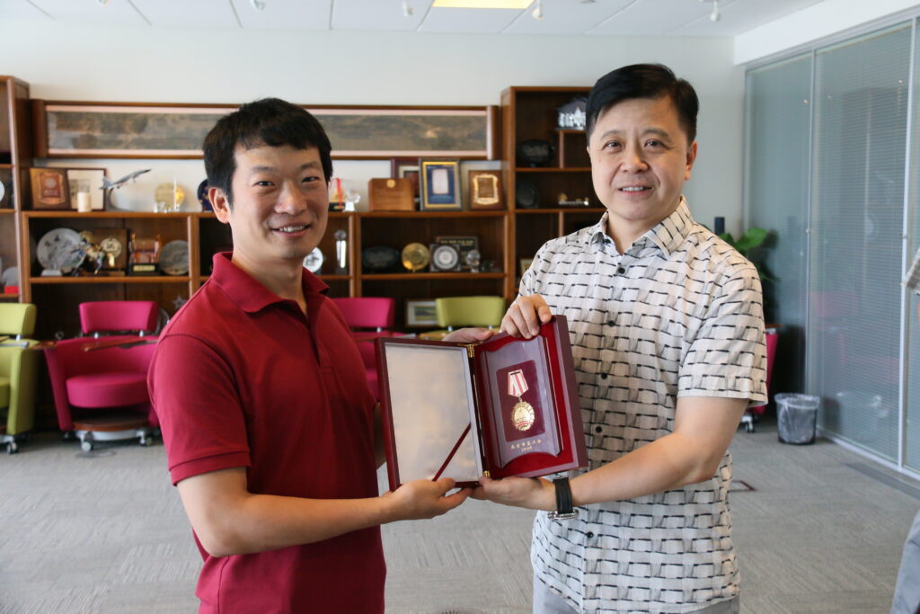 微软亚洲研究院院长洪小文(右)为陈刚(左)颁发首都劳动奖章