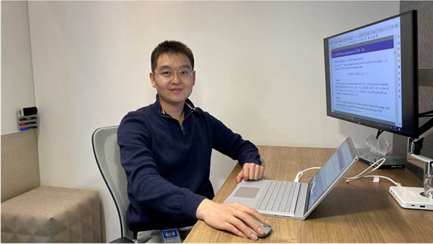 a person sitting at a desk in front of a laptop computer