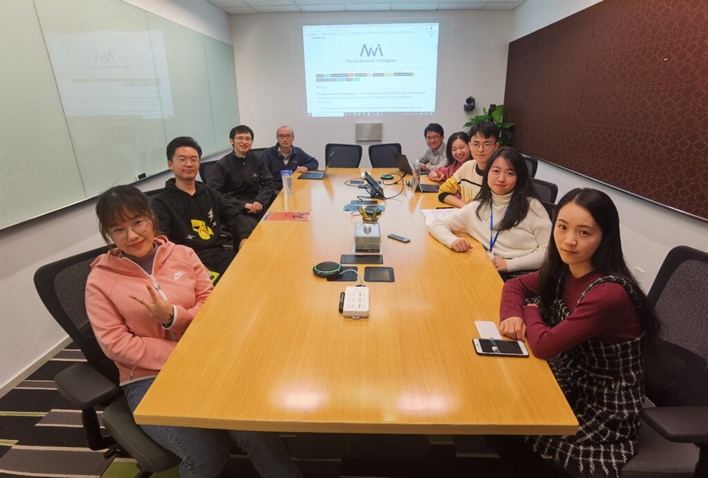 a group of people sitting at a table with a laptop
