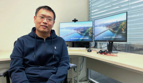 Joe Chen standing in front of a computer
