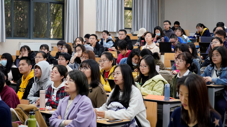 a group of people sitting at a table in front of a crowd