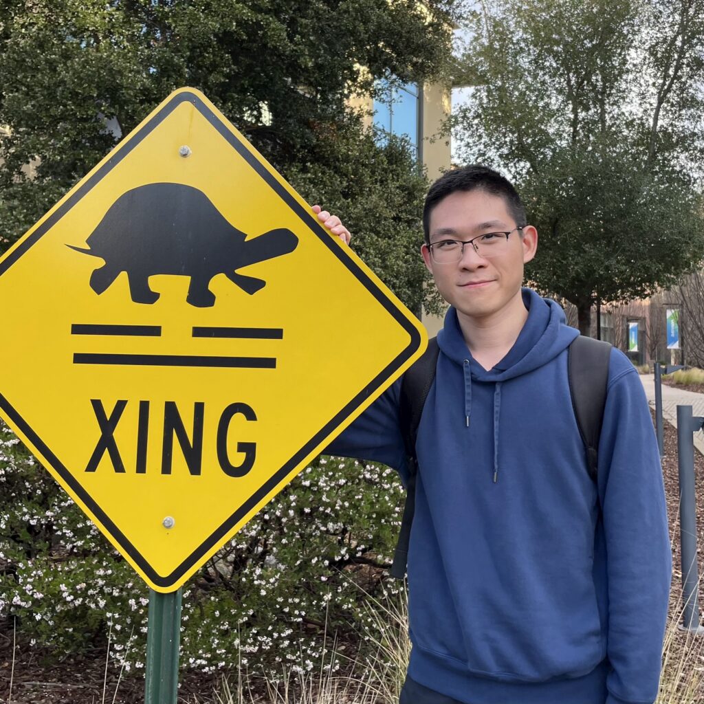 a man standing next to a sign
