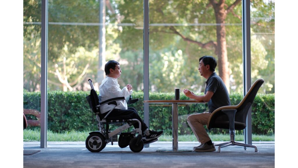 Xiaoyuanli and his colleague discussing in front of a window