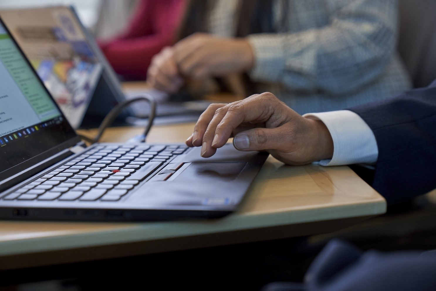 Image of a hand hovering over a keyboard.
