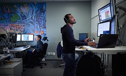 Image of a tech worker looking at a computer monitor.