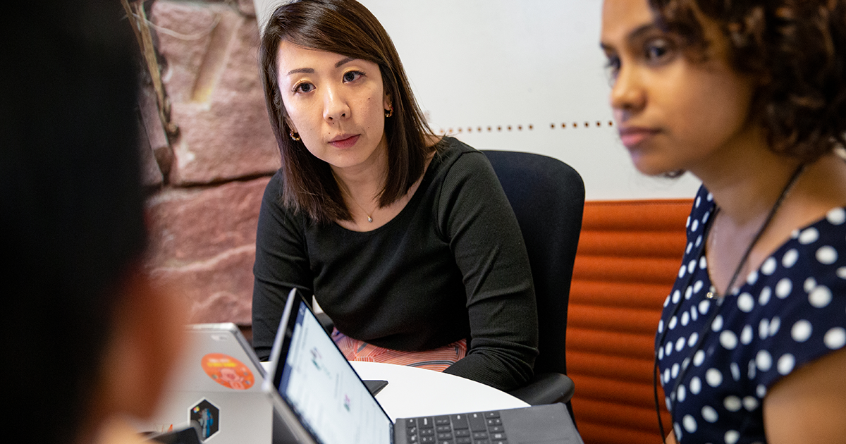 Image of several employees gathered around a desk.