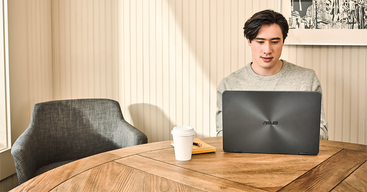 Young man interacting with an Asus Zenbook laptop.