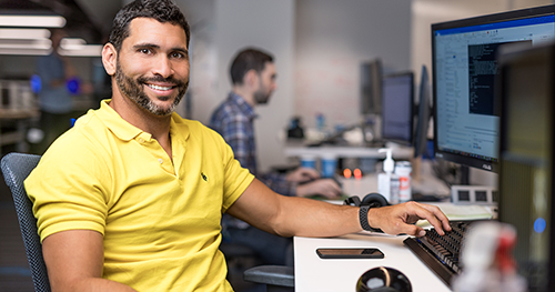 An image of a tech worker sitting at his desk.