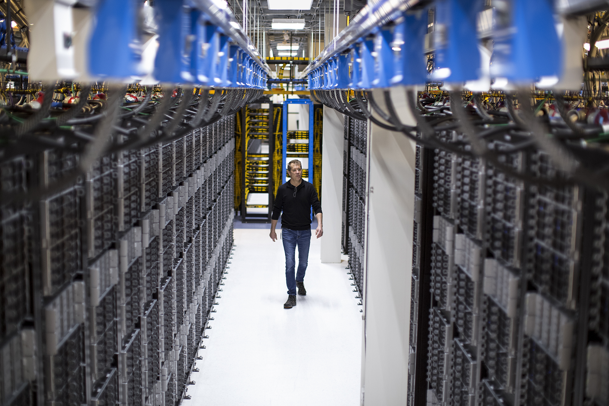 image of a man walking through a State-of-the-art facility uses eco-friendly solutions such as using reclaimed water to cool the data center.