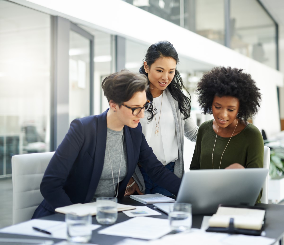 Shot of a group of businesswomen using a laptop during a meeting at work.