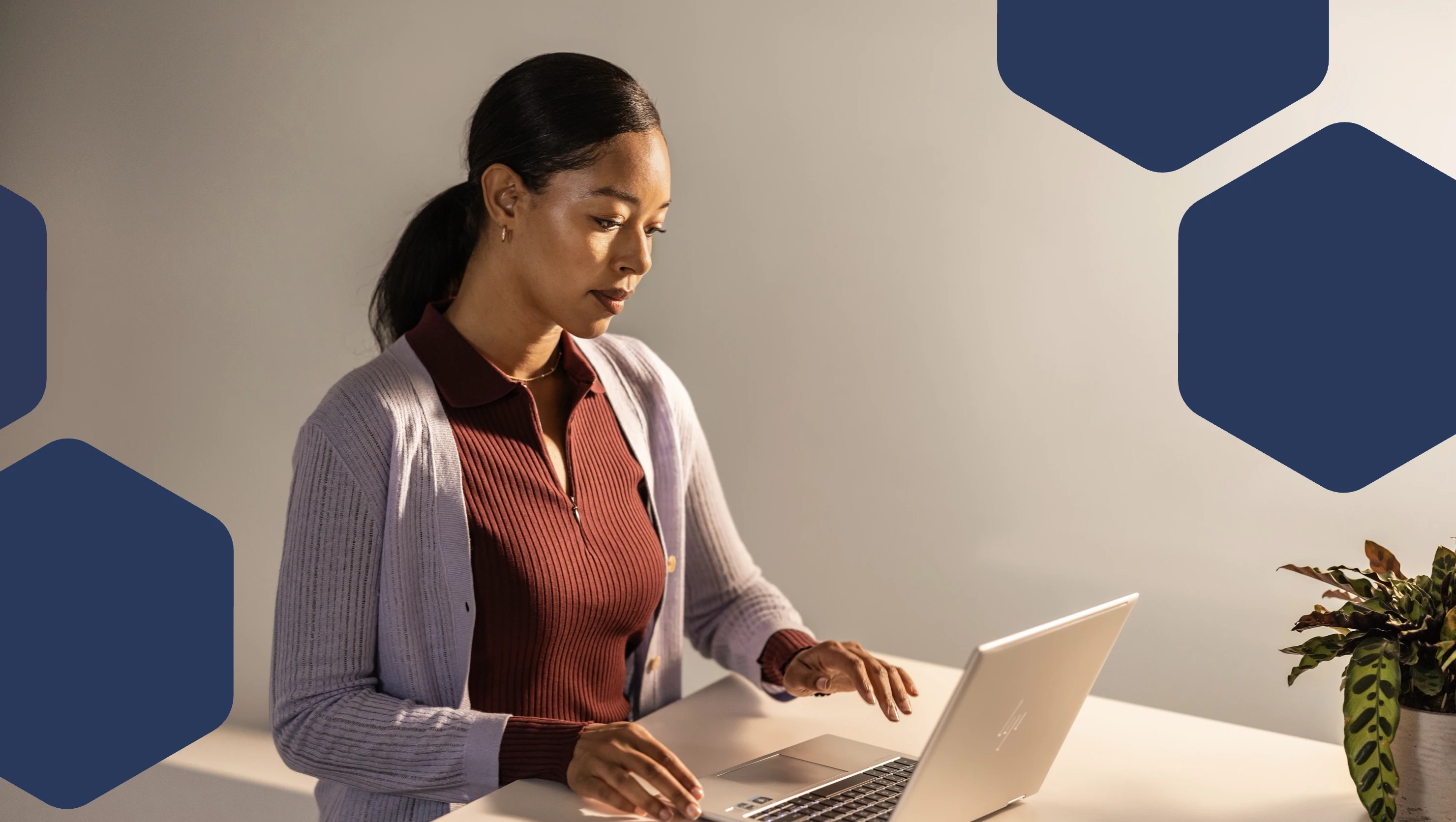 A woman sitting at a desk using a laptop