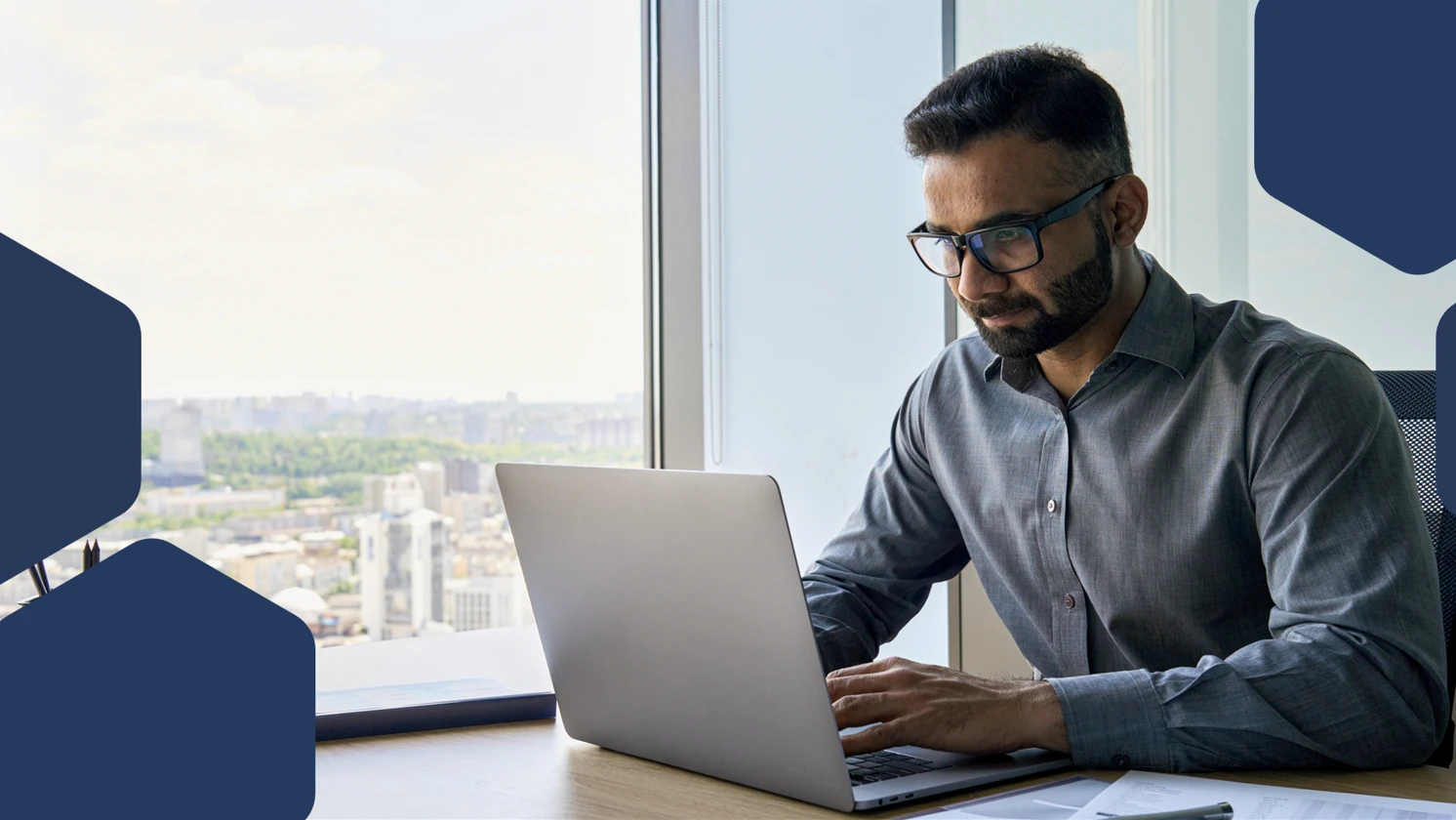 Photo of a man sitting at a desk with a laptop
