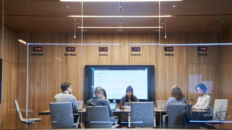 A group of people sitting at a table in a conference room.