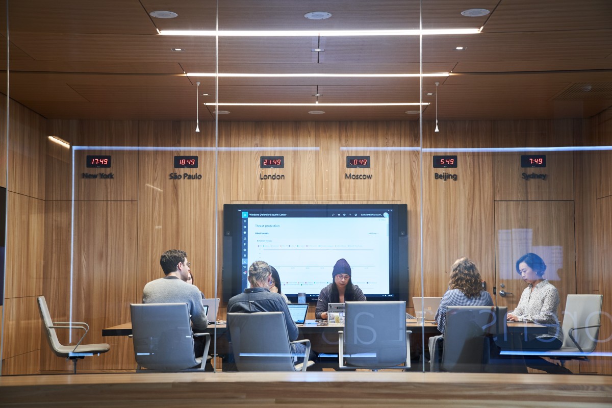 A group of people sitting at a table in a conference room.