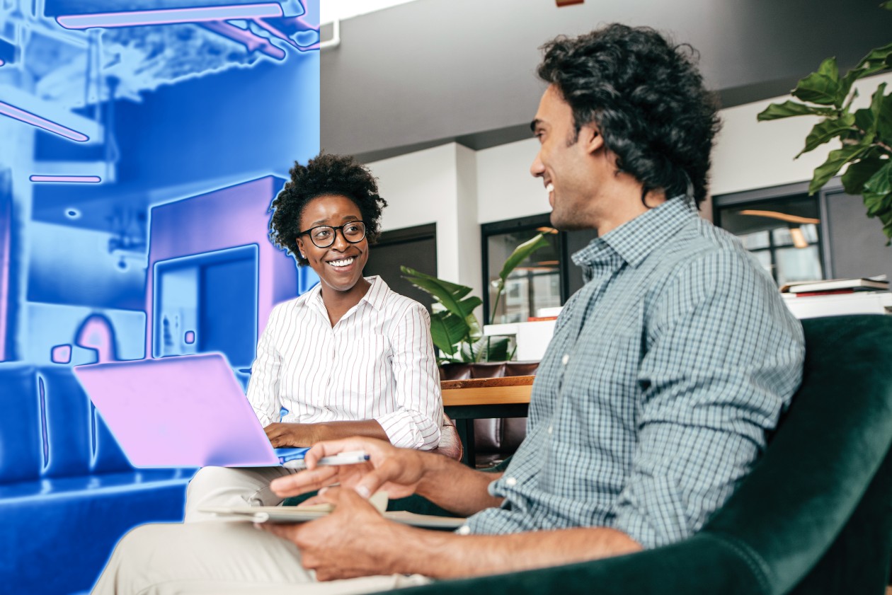 A man and woman sitting in a chair looking at a laptop.