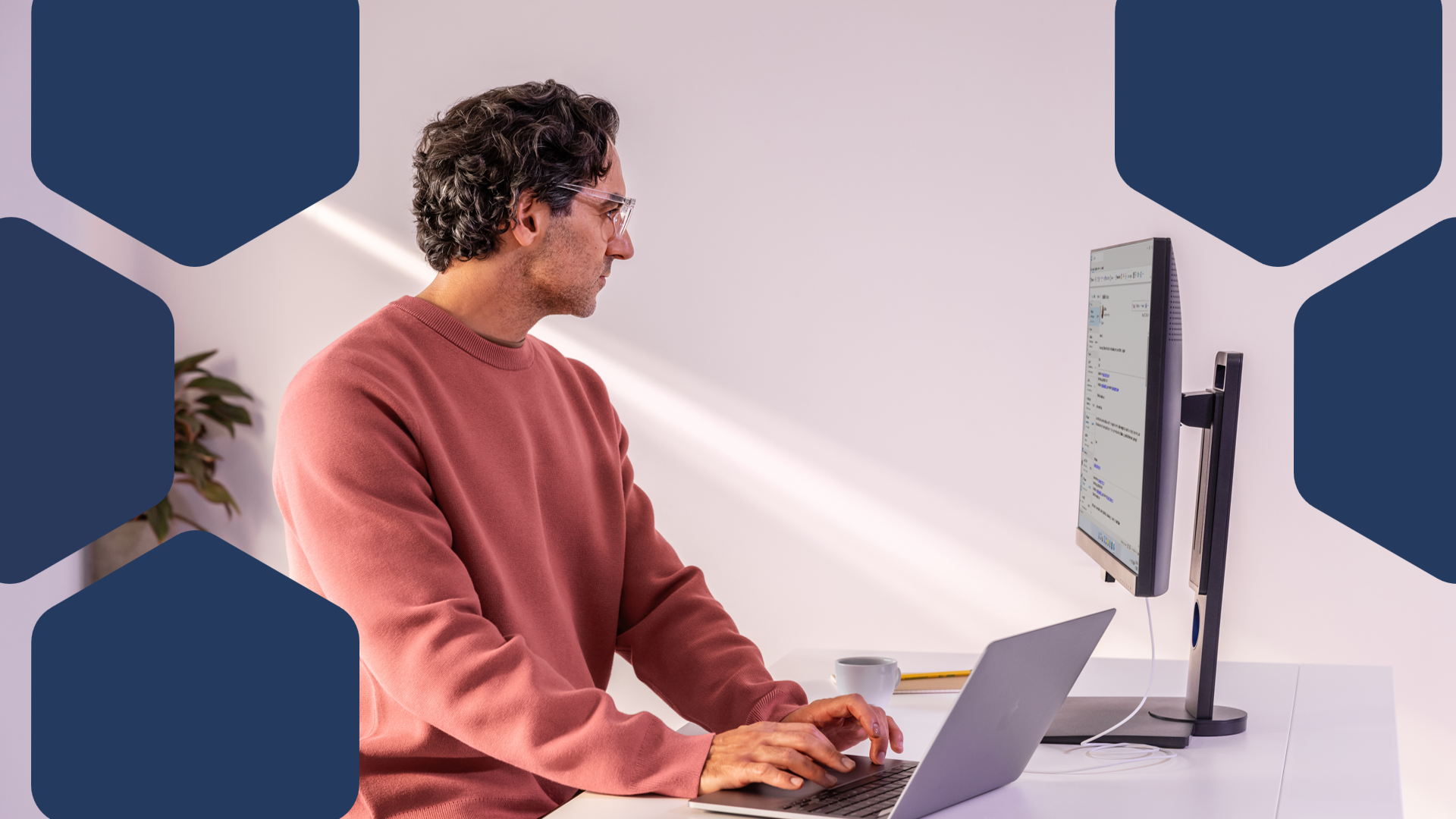 A man sitting at a desk using a laptop