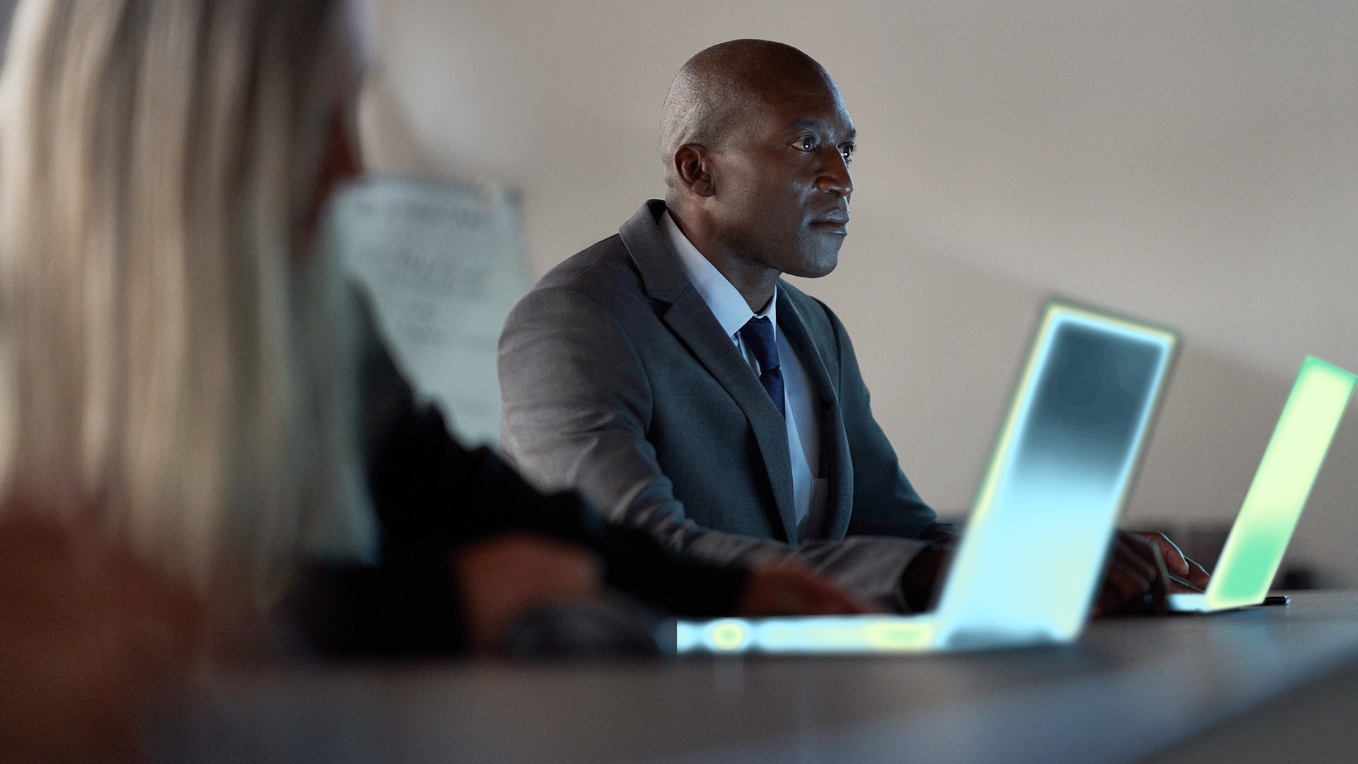 A man in a suit and tie looking at a laptop.