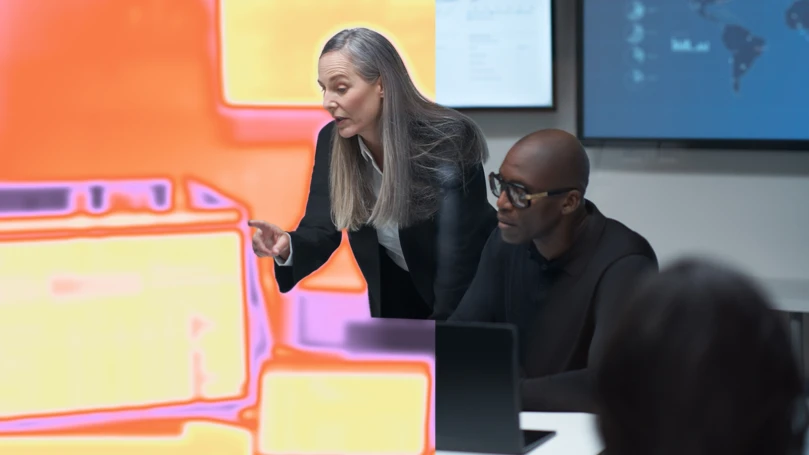 A woman pointing at a computer.