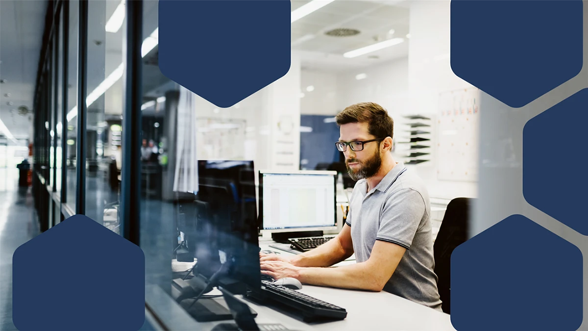 Photo of an engineer in control room of a factory working on computer