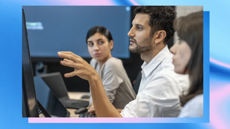 Three people sit at computers in a security operations center.