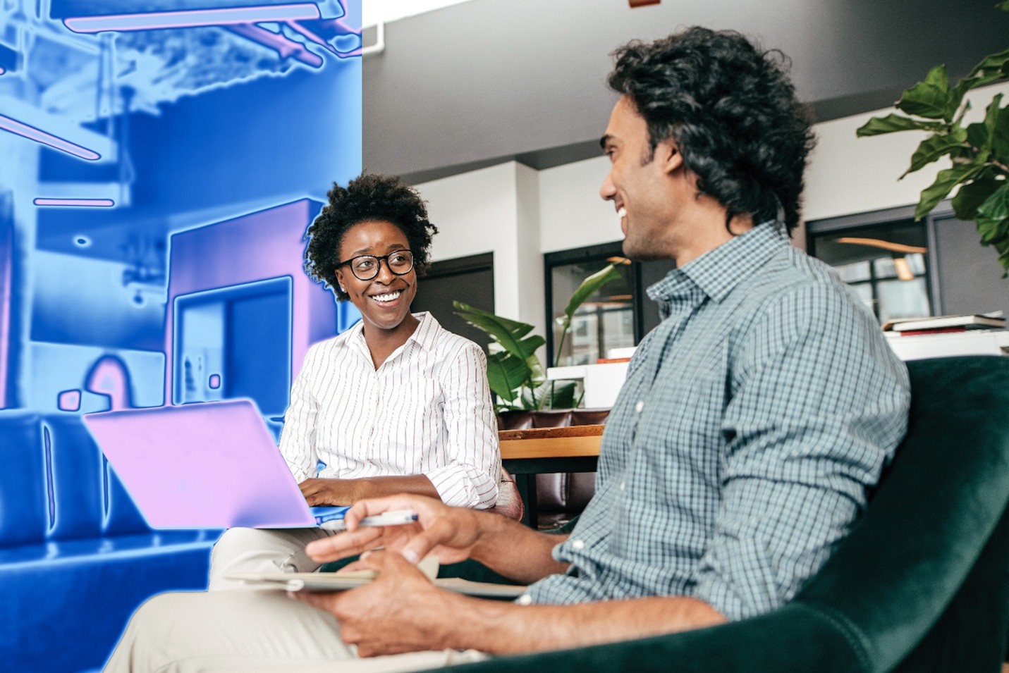 Two people on a security team sit at laptops together.