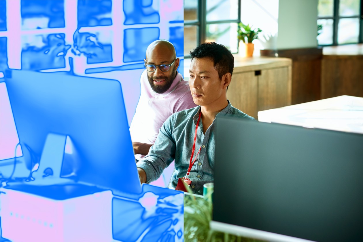 Two men looking at a computer monitor.