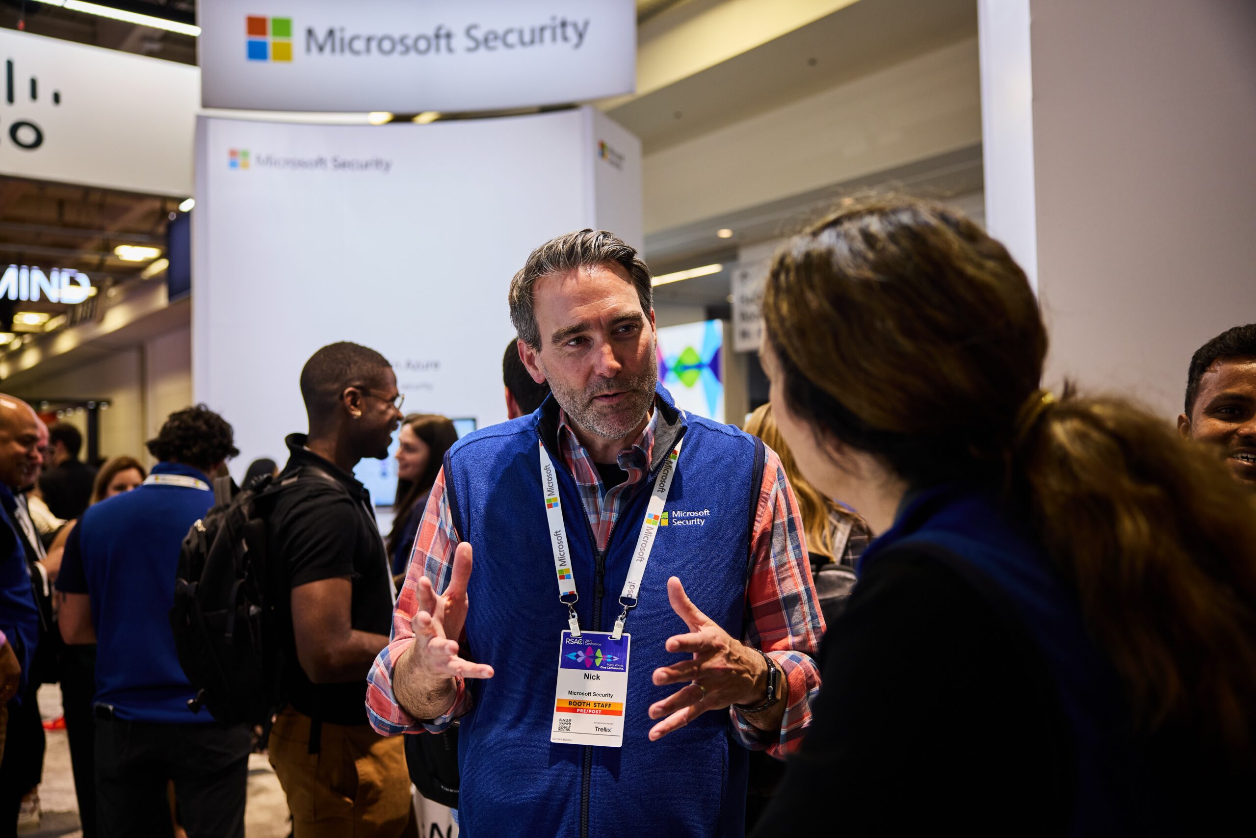 People talking near a Microsoft Security booth.