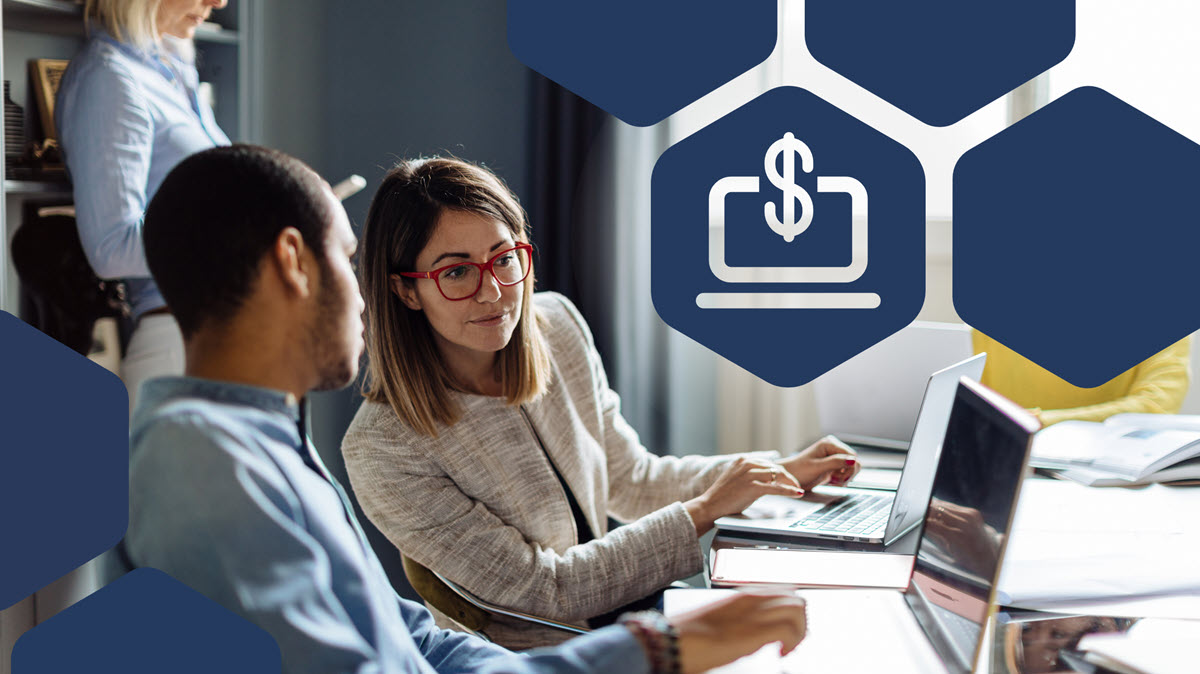 Office workers looking at computers in a conference room