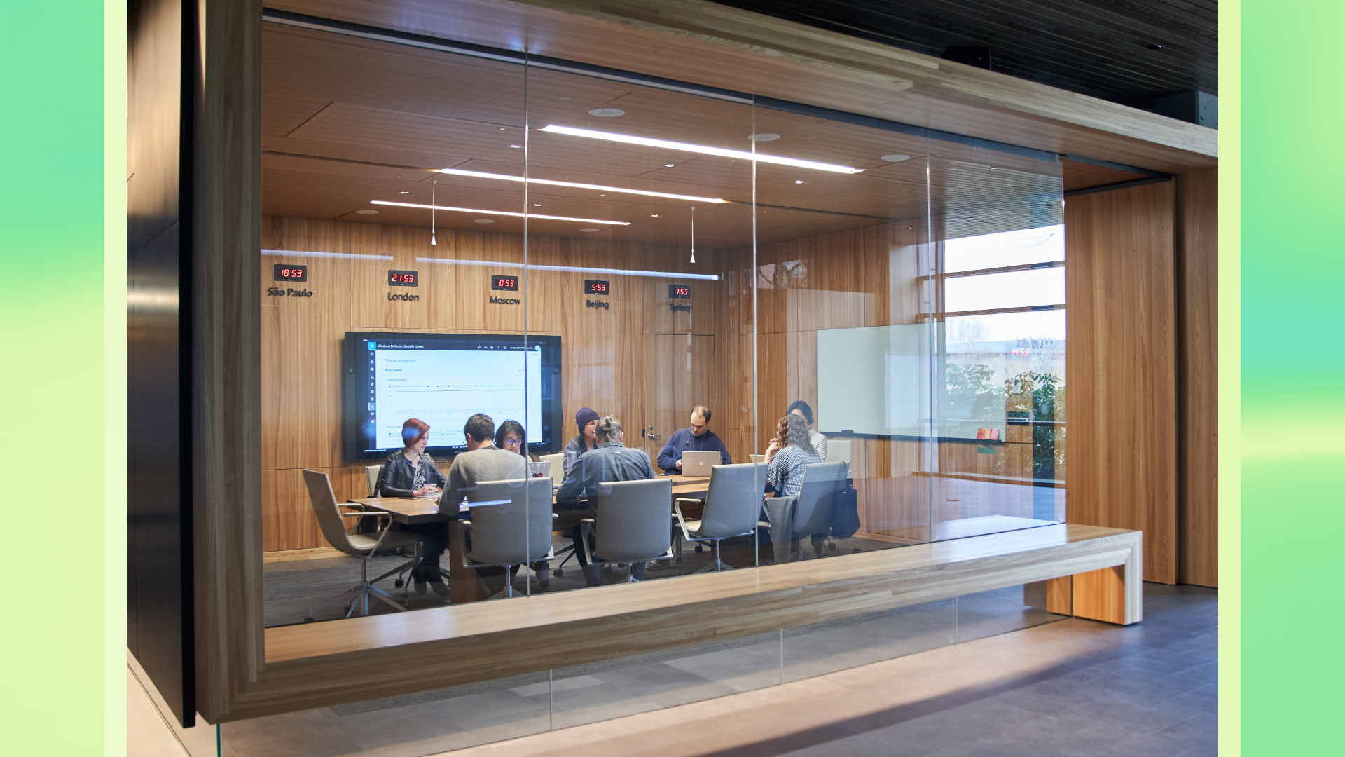 Outside of a conference room or board room meeting including people sitting around table in a room with international time clocks