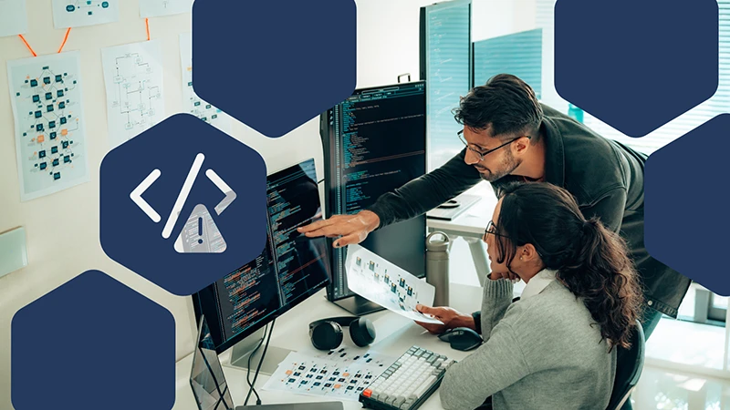 Photo of two developers collaborating looking at code on a computer screen