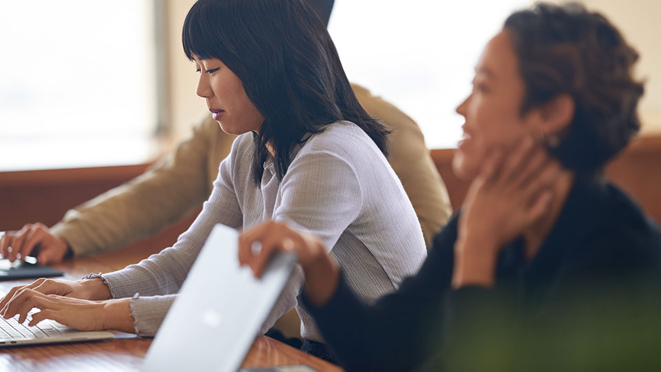 People watching a presentation together a table with their laptops