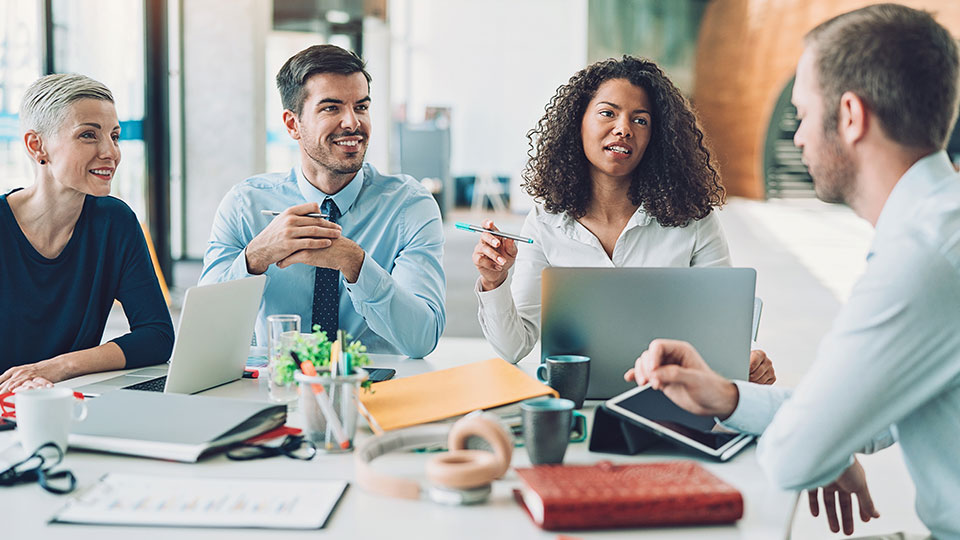 Coworkers in conversation at a conference table