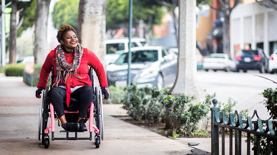 A woman in a wheelchair on the sidewalk
