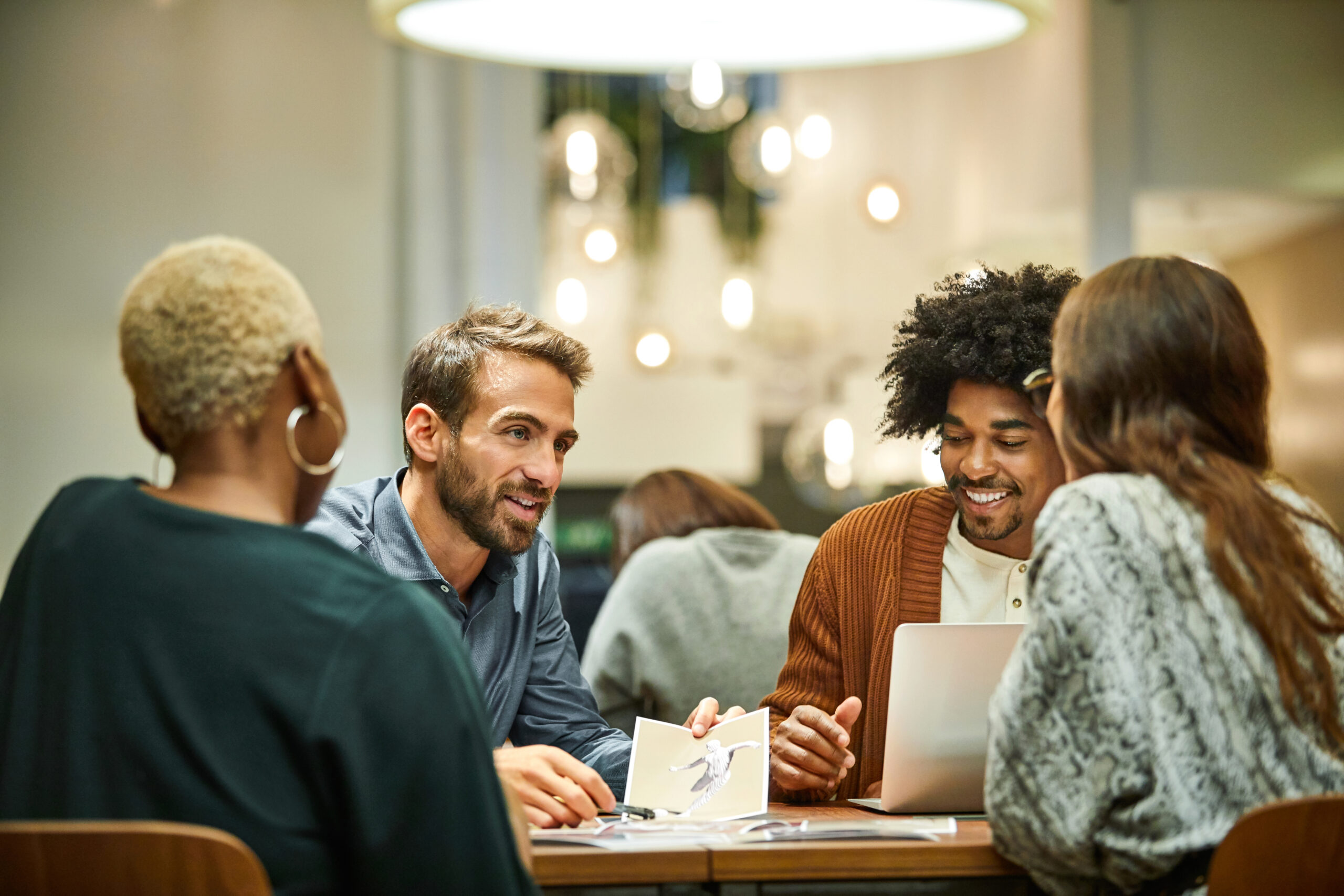 A diverse set of startup founders meeting in a glass conference room.