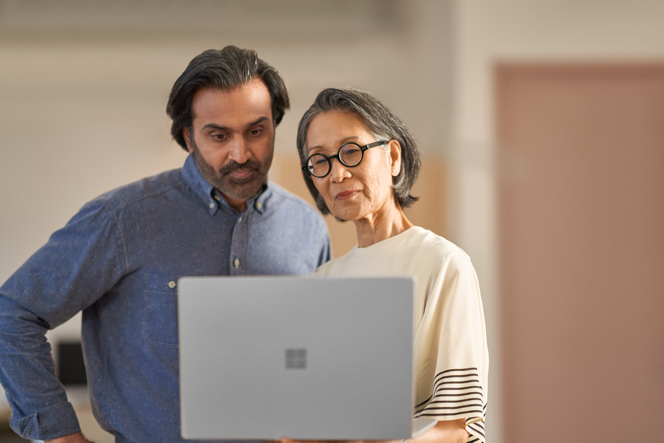 Man talking to woman with laptop