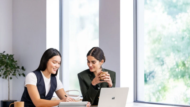 Photograph of two female personas sitting at a cafe counter.