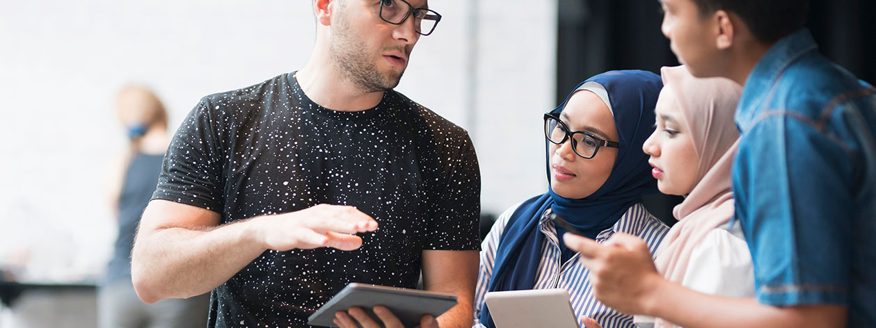 En lærer, der peger på en projiceret skærm i et klasseværelse